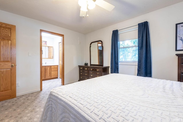 bedroom with light carpet, ceiling fan, connected bathroom, and baseboards