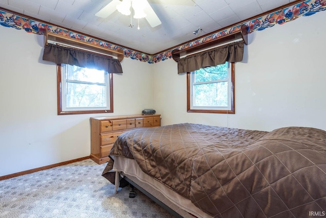 bedroom with carpet floors, multiple windows, baseboards, and a ceiling fan