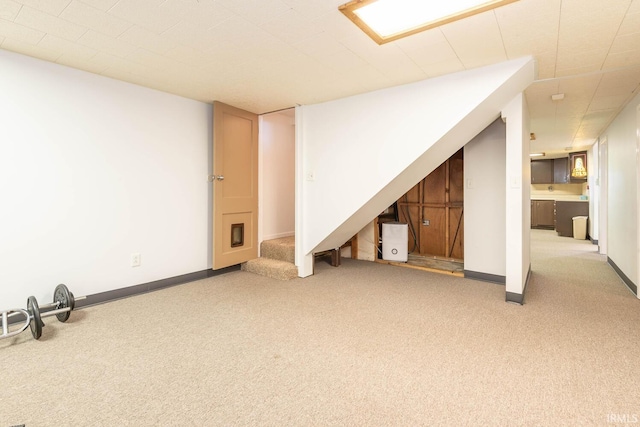 finished below grade area with stairs, carpet flooring, and baseboards