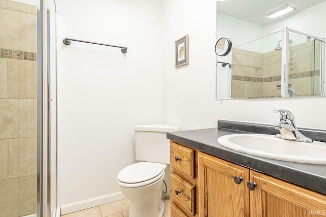 full bathroom featuring toilet, vanity, baseboards, a shower stall, and tile patterned floors