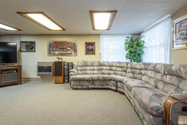 living room with carpet flooring, concrete block wall, and heating unit