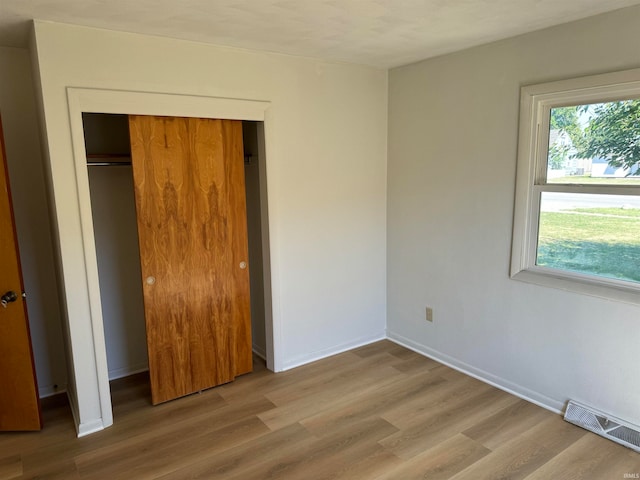 unfurnished bedroom featuring hardwood / wood-style floors and a closet