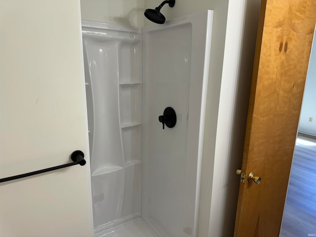 bathroom with hardwood / wood-style flooring and a shower