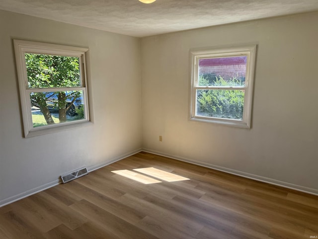 unfurnished room featuring a textured ceiling and wood-type flooring