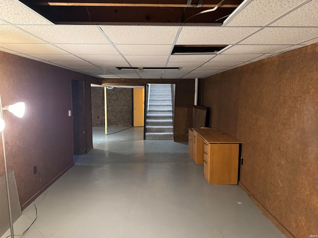 interior space featuring a paneled ceiling and concrete floors