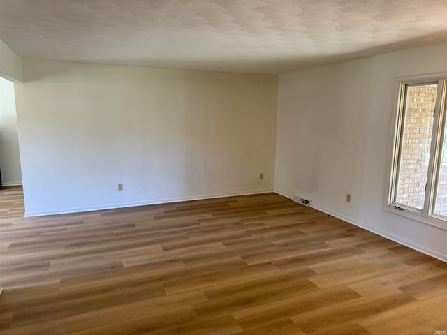 unfurnished room featuring a textured ceiling and wood-type flooring