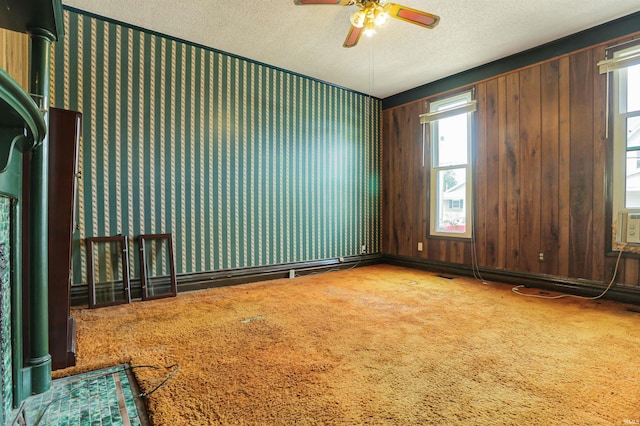 carpeted empty room featuring a ceiling fan and a textured ceiling