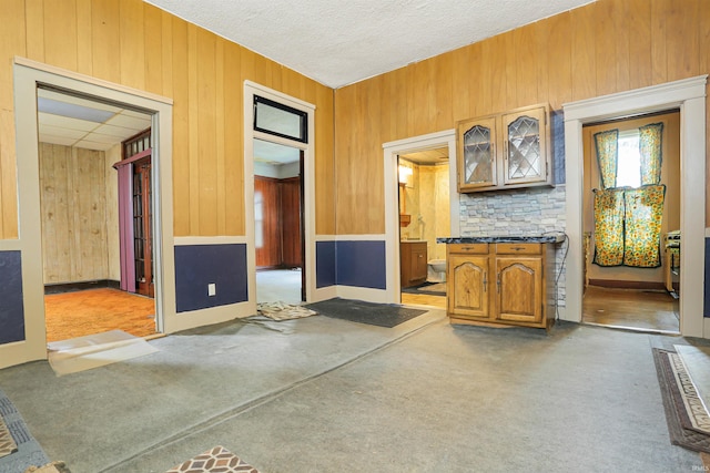 interior space featuring wooden walls and a textured ceiling