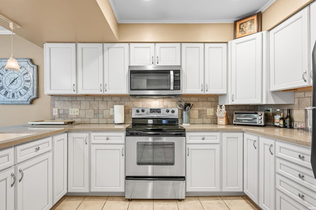 kitchen featuring backsplash, hanging light fixtures, stainless steel appliances, white cabinetry, and light tile patterned flooring