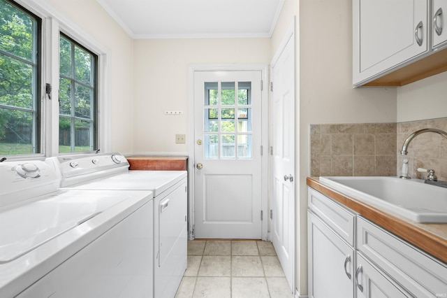 clothes washing area featuring cabinets, a healthy amount of sunlight, sink, and washer and clothes dryer