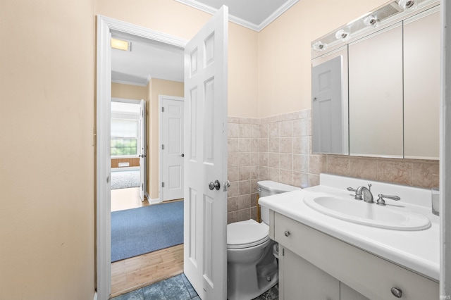 bathroom with vanity, tile walls, toilet, ornamental molding, and hardwood / wood-style flooring