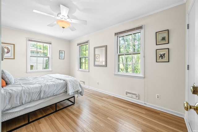 bedroom with light wood-type flooring, ceiling fan, and ornamental molding