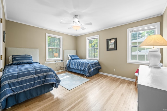 bedroom with ceiling fan, ornamental molding, and light hardwood / wood-style flooring