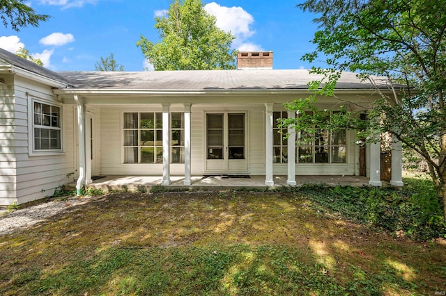 back of house featuring a lawn and a patio