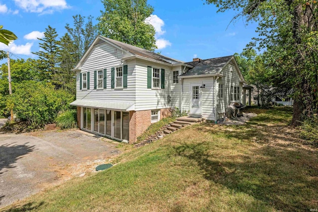 exterior space featuring a lawn and a sunroom