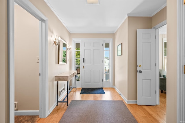 entryway with ornamental molding and light wood-type flooring