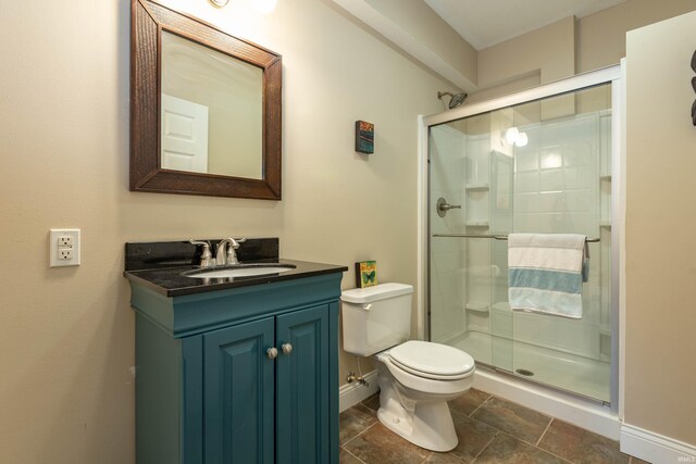 bathroom with vanity, toilet, and a shower with door