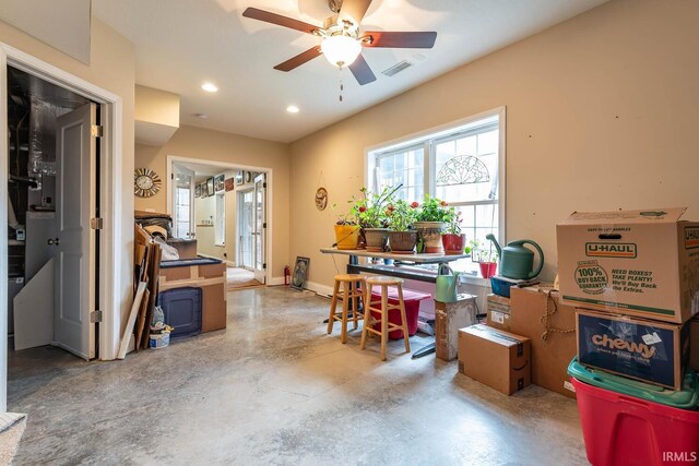 interior space featuring ceiling fan and concrete flooring