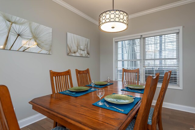 dining area with ornamental molding and dark hardwood / wood-style floors