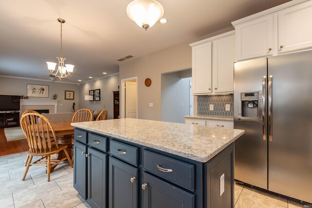 kitchen with pendant lighting, stainless steel fridge with ice dispenser, decorative backsplash, a chandelier, and white cabinetry