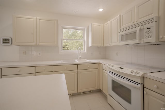 kitchen with backsplash, light countertops, a sink, and white appliances