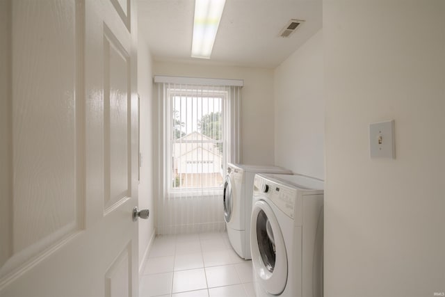 laundry area featuring washing machine and clothes dryer, visible vents, laundry area, and light tile patterned flooring