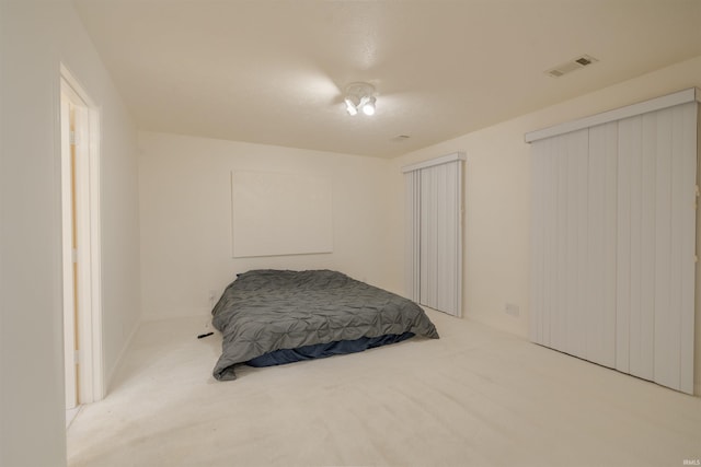 carpeted bedroom featuring visible vents