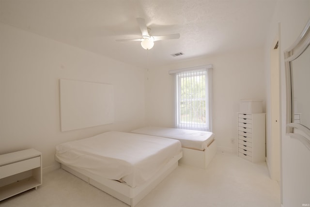 bedroom featuring visible vents, ceiling fan, carpet, and a textured ceiling