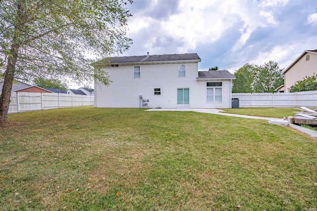 back of property featuring a fenced backyard and a lawn