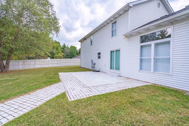 rear view of property with a lawn, fence, and a patio