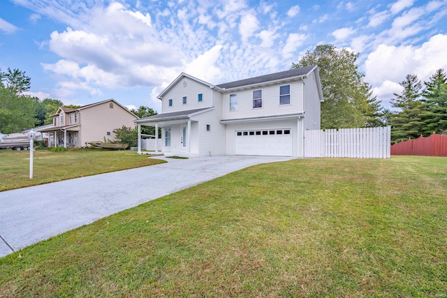 traditional-style house featuring driveway, a front lawn, fence, and an attached garage