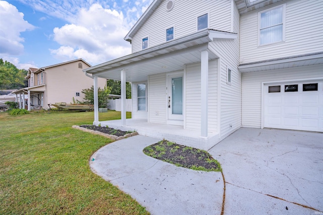 exterior space with an attached garage, concrete driveway, covered porch, and a front yard