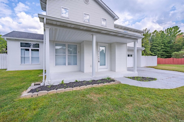 view of front of house featuring driveway, a front yard, covered porch, and fence