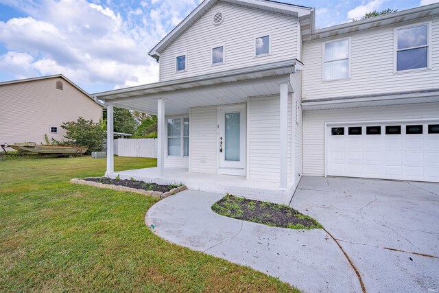view of front of home featuring covered porch, concrete driveway, an attached garage, and a front lawn