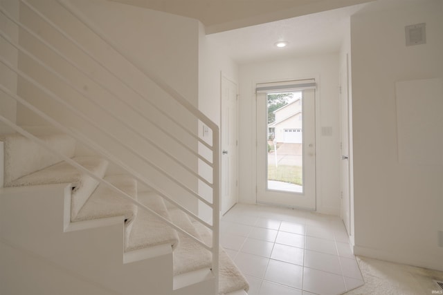 doorway to outside with light tile patterned flooring, stairs, visible vents, and baseboards