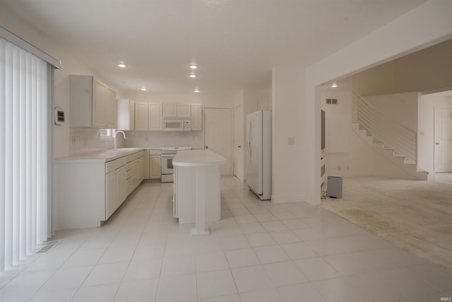 kitchen with a kitchen island, white appliances, light tile patterned floors, tasteful backsplash, and sink