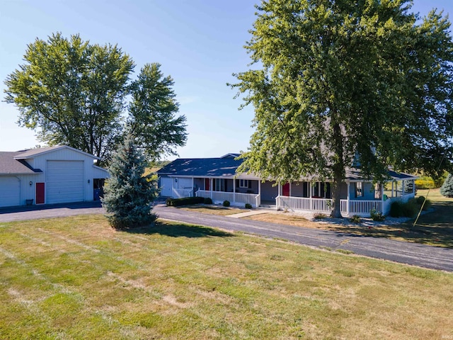 view of front of house featuring a front lawn, covered porch, and a garage