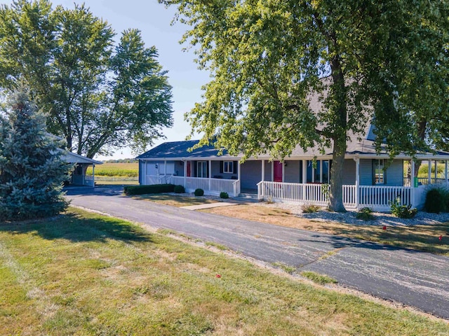 ranch-style house with covered porch, a carport, and a front lawn