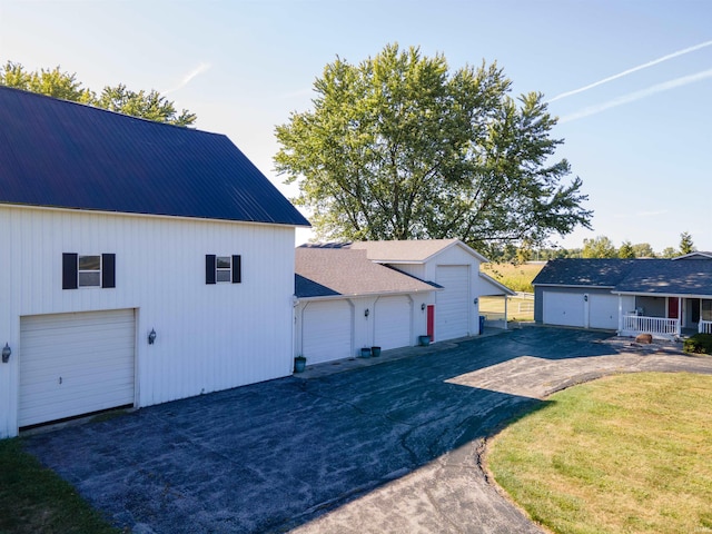 view of property exterior with a garage and a lawn