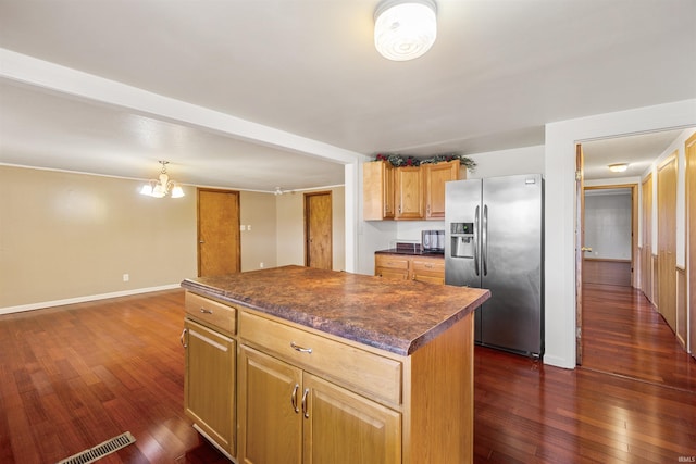 kitchen with stainless steel fridge, a chandelier, a kitchen island, and dark hardwood / wood-style floors