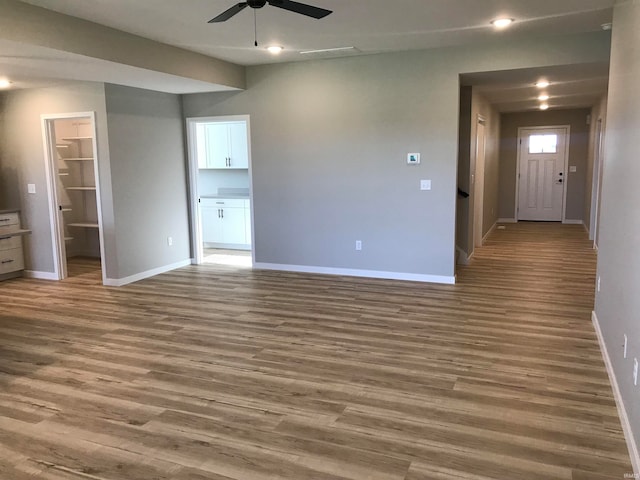 interior space with ceiling fan, baseboards, wood finished floors, and recessed lighting