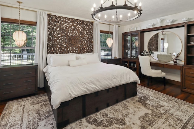 bedroom featuring a chandelier and dark hardwood / wood-style flooring