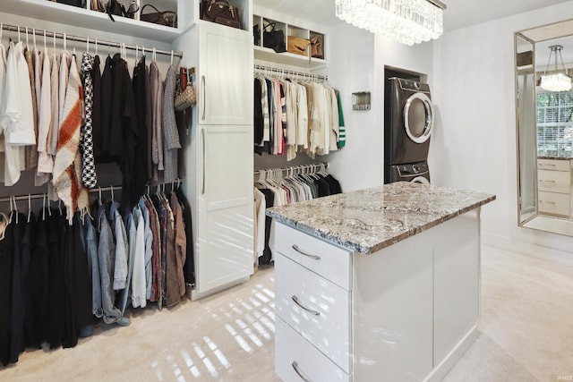 spacious closet with stacked washing maching and dryer and light carpet