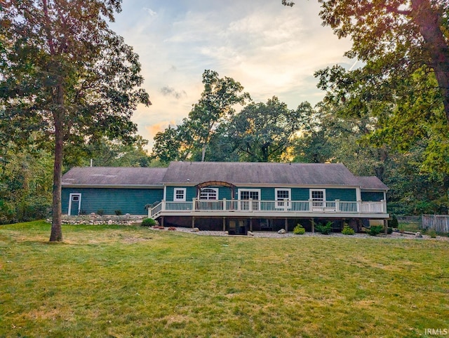 ranch-style home featuring a yard and a wooden deck