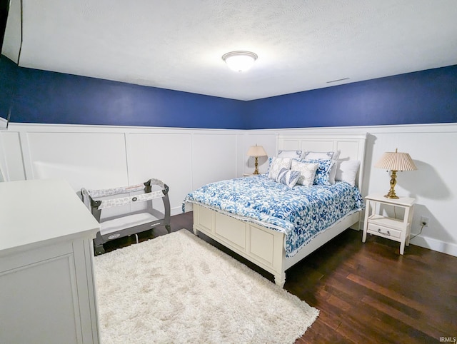 bedroom featuring a textured ceiling and dark hardwood / wood-style floors