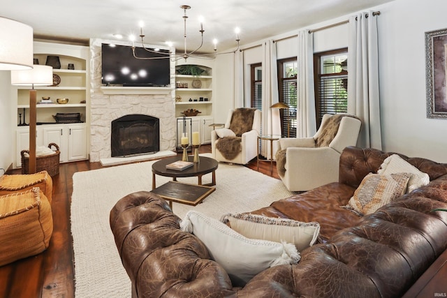 living room featuring a fireplace, a chandelier, hardwood / wood-style flooring, and built in shelves