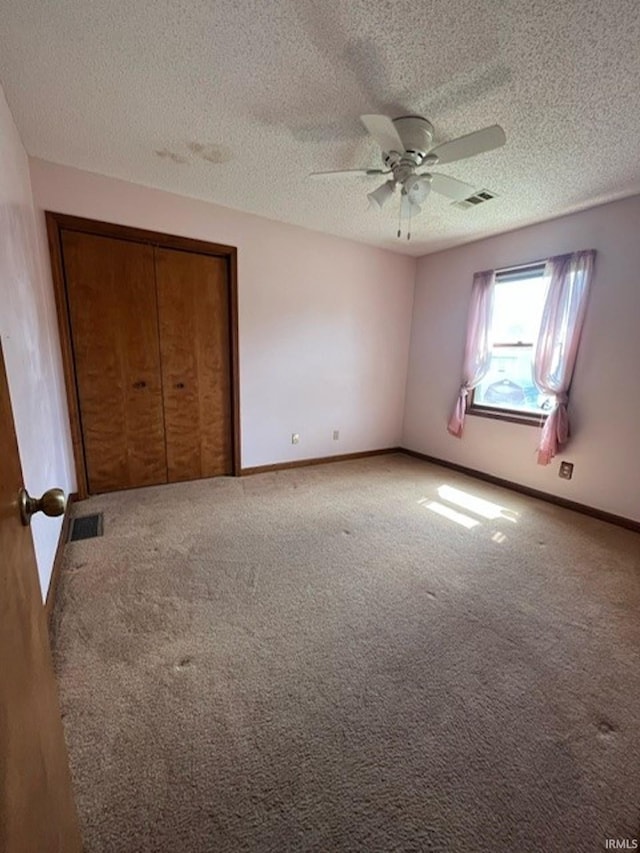 unfurnished bedroom featuring a textured ceiling, carpet, ceiling fan, and a closet