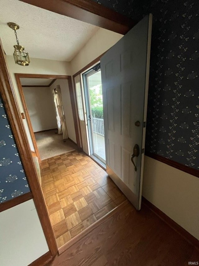 doorway featuring a textured ceiling and parquet flooring