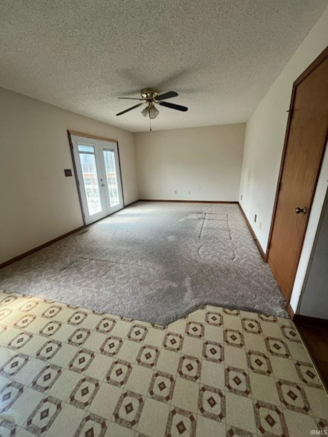 carpeted empty room with ceiling fan and a textured ceiling