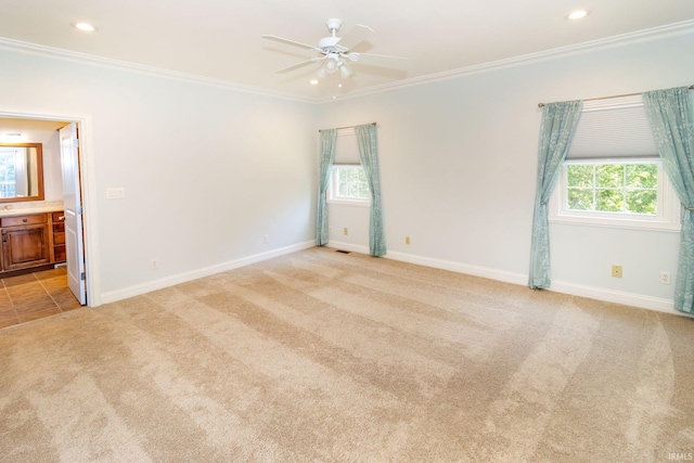 empty room featuring light colored carpet, ceiling fan, and ornamental molding